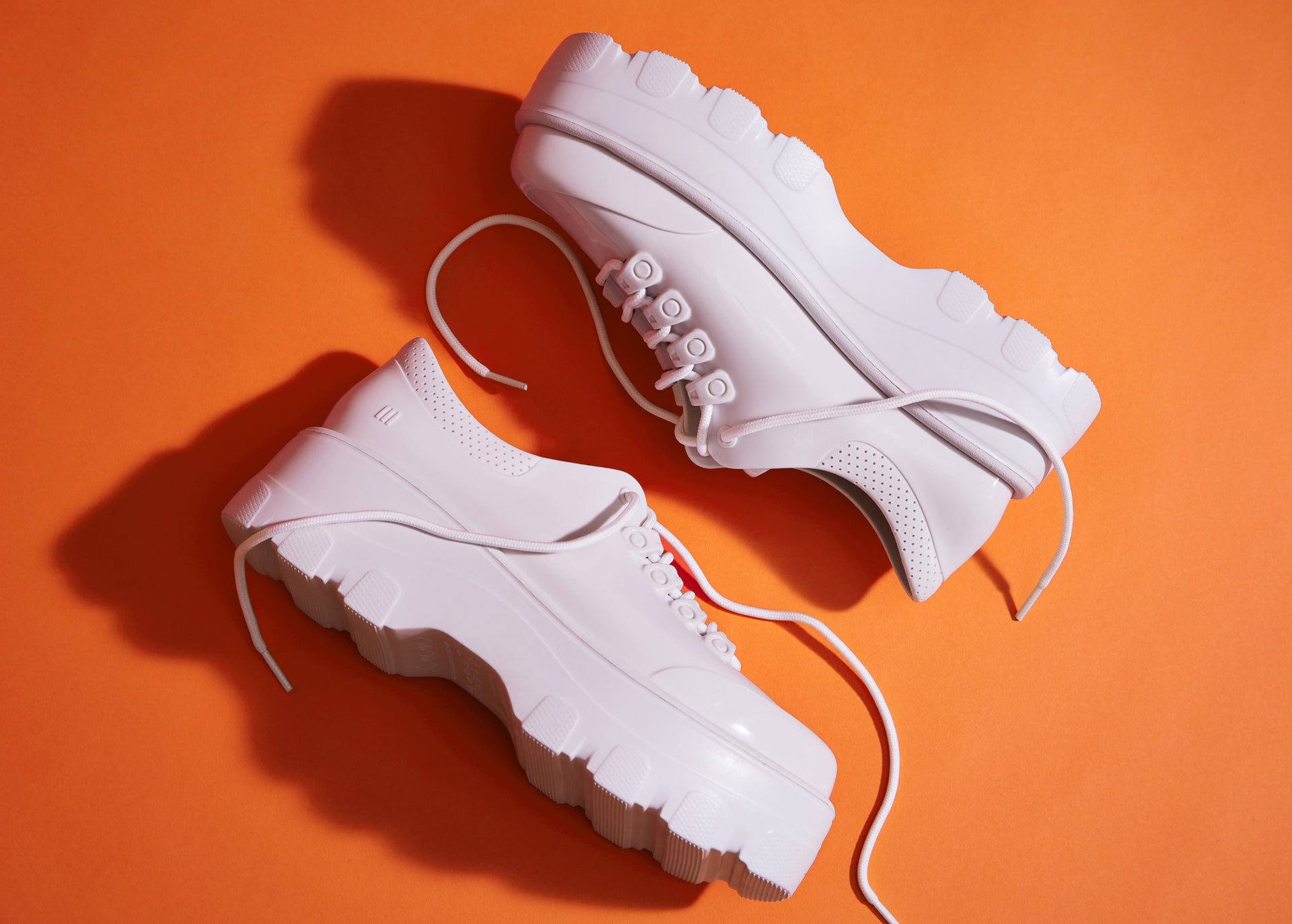 pair of white kick off sneakers lying on the floor