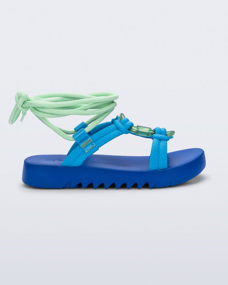 Side view of an blue sole, blue upper, and green ankle strap Kirk + Alexandre Pavao sandal