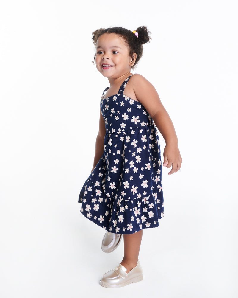 Child model in a blue with flowers dress wearing a pair of metallic beige Royal Love baby loafers