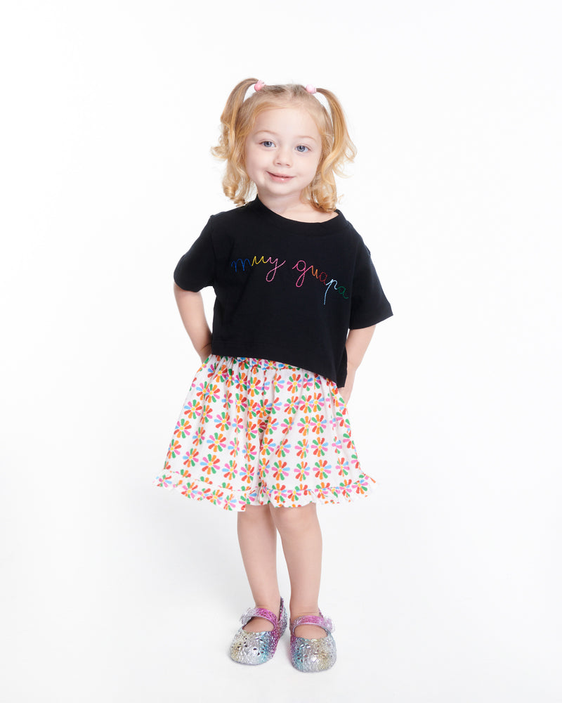 Child model in a skirt and black top wearing a pair of pearly multicolor Pollen baby flats