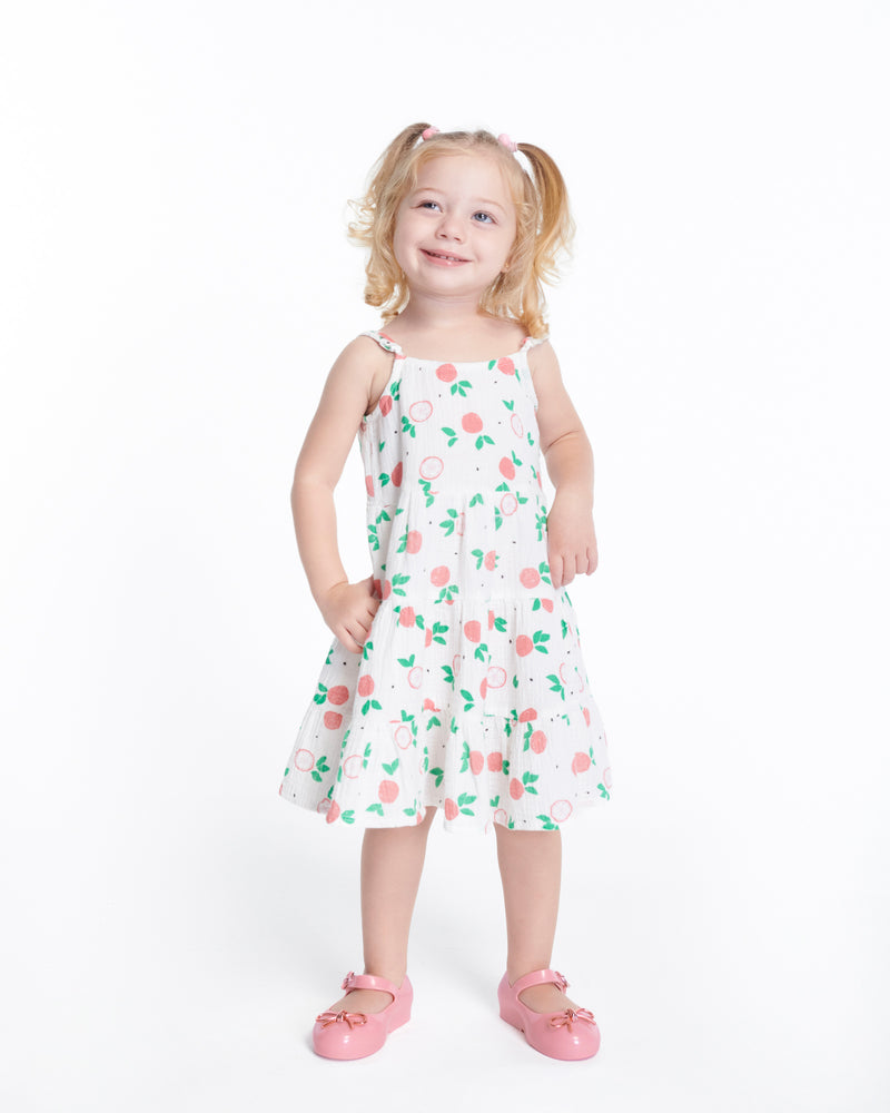 Child model in a dress wearing a pair of pink Sweet Love Chrome baby flats with metallic pink bow and buckle