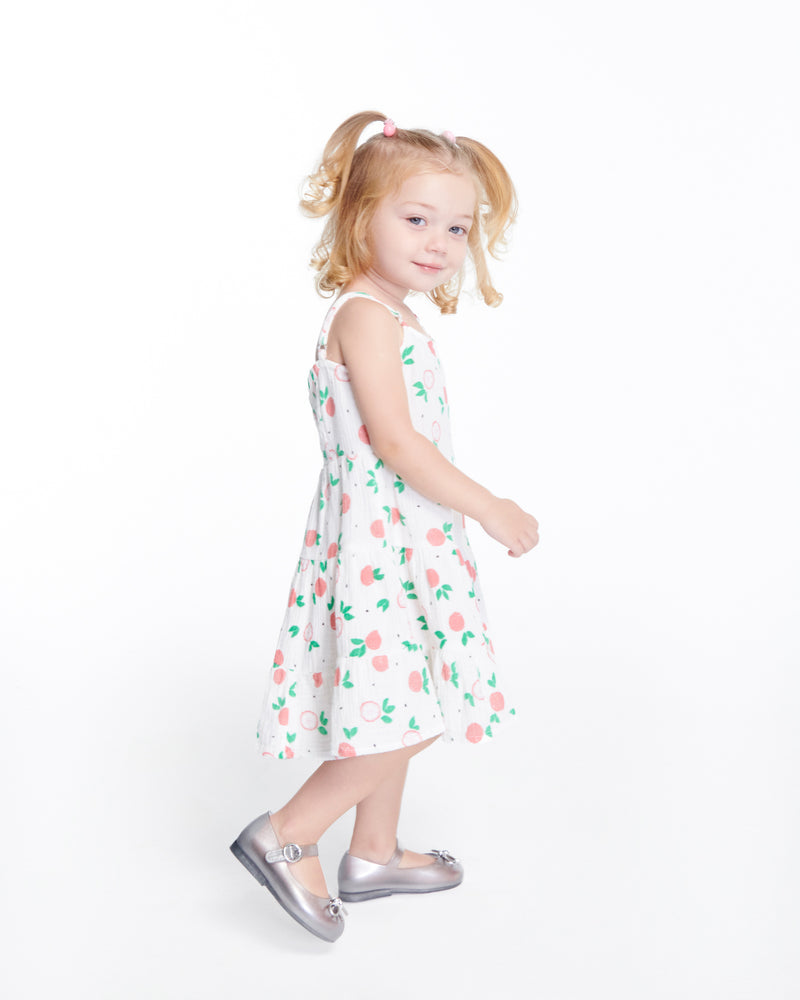 Child model in a dress wearing a pair of silver Sweet Love Chrome baby flats with metallic silver bow and buckle
