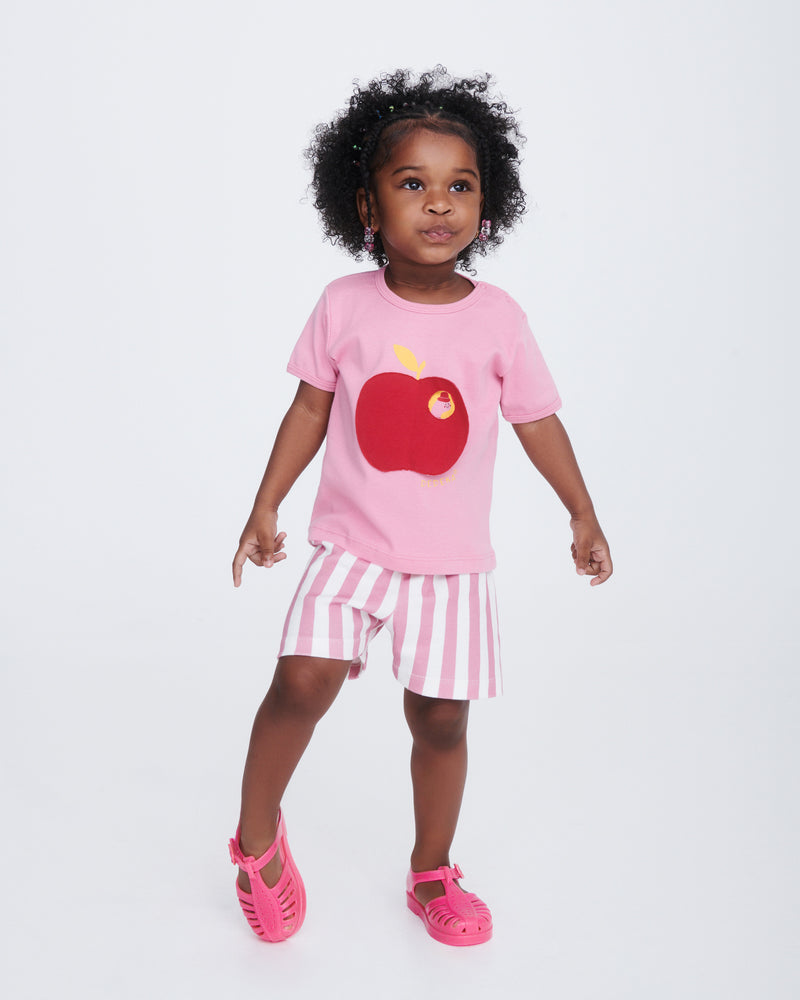 Child model in pink shorts and shirt wearing a pair of pink Aranha 79 baby flats with buckle