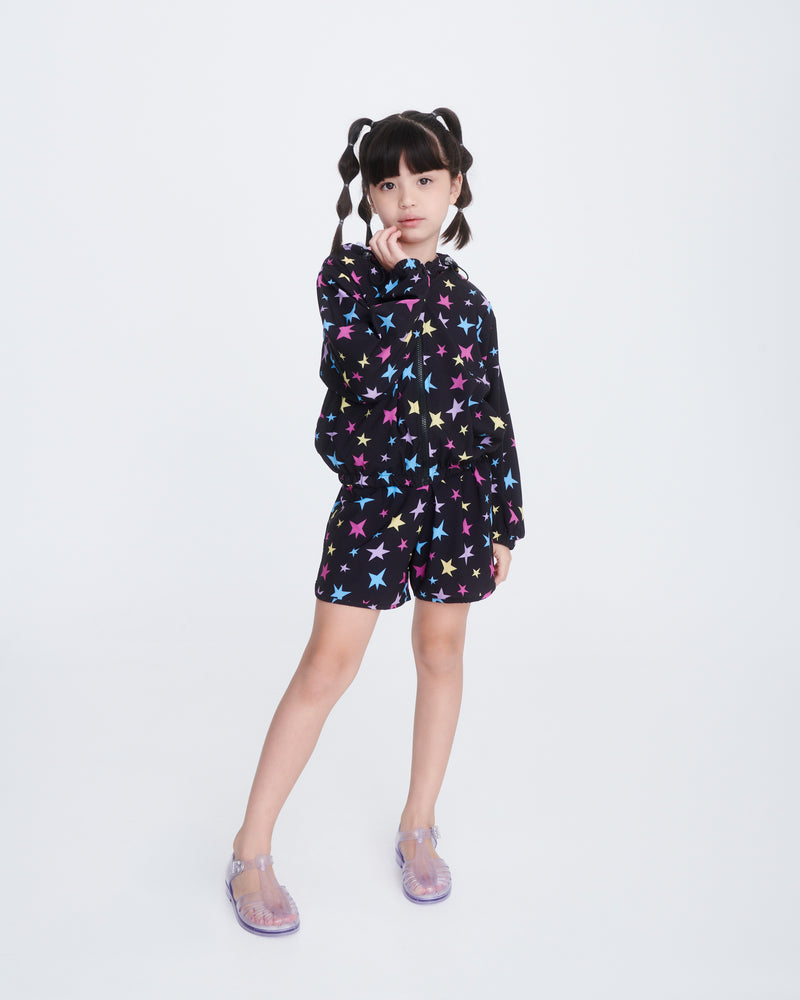 Child model in black shorts and shirt wearing a pair of clear Aranha 79 kids flats with buckle