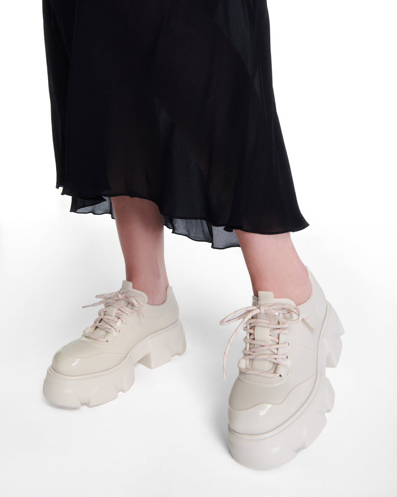 Model's legs wearing a pair of beige Camp platform Sneakers with beige laces
