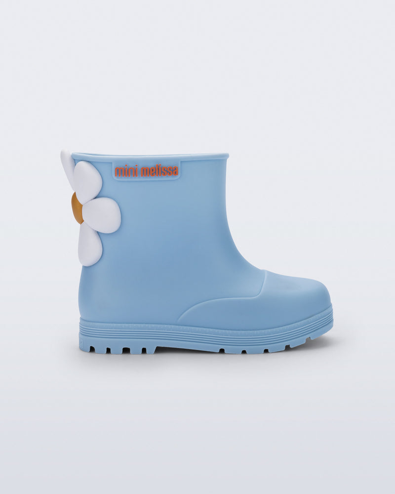 Side view of a blue Welly Bloomy boot with white daisy on back