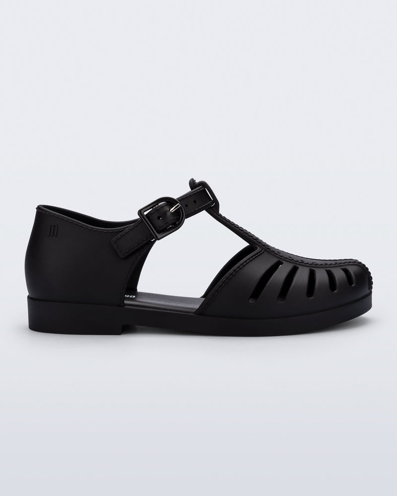 Side view of a black Aranha 79 kids flat with buckle