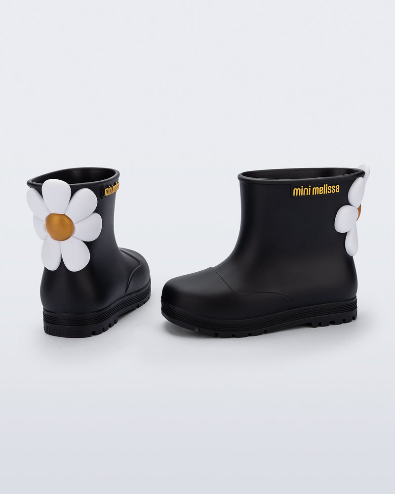 Side and back view of a pair of black Welly Bloomy boots with white daisy on back