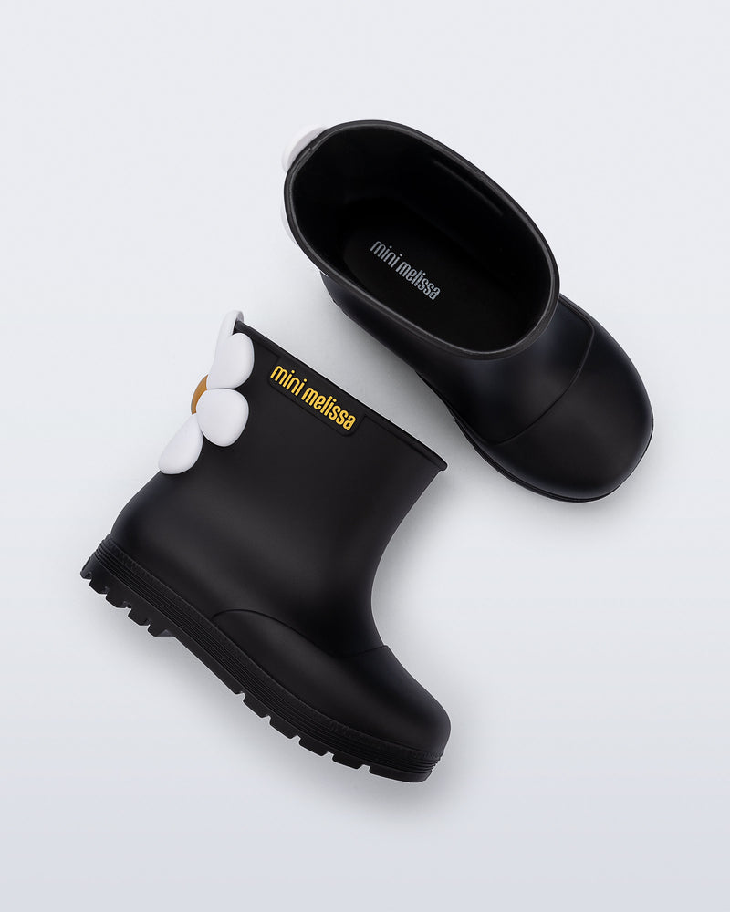 Side and top view of a pair of black Welly Bloomy boots with white daisy on back