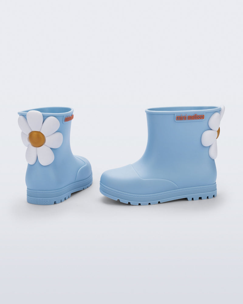 Side and back view of a pair of blue Welly Bloomy boots with white daisy on back