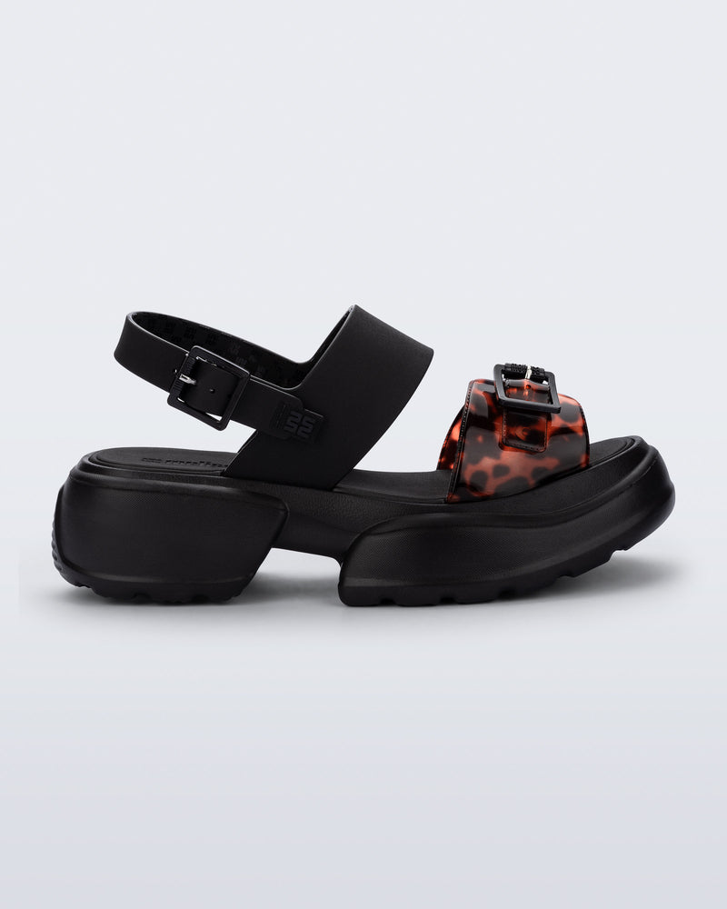 Side view of a black Push platform Sandal with tortoise colored strap