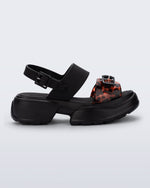 Side view of a black Push platform Sandal with tortoise colored strap