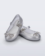 Angled view of a pair of Silver Sweet Love Chrome baby flats with metallic silver bow and buckle