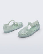 Back and angled view of a pair of milky green Aranha 79 flats with buckle