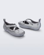 Back and angled view of a pair of silver Aira flats with top straps