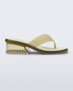 Side view of a beige Margot flip flop with clear beige low heel