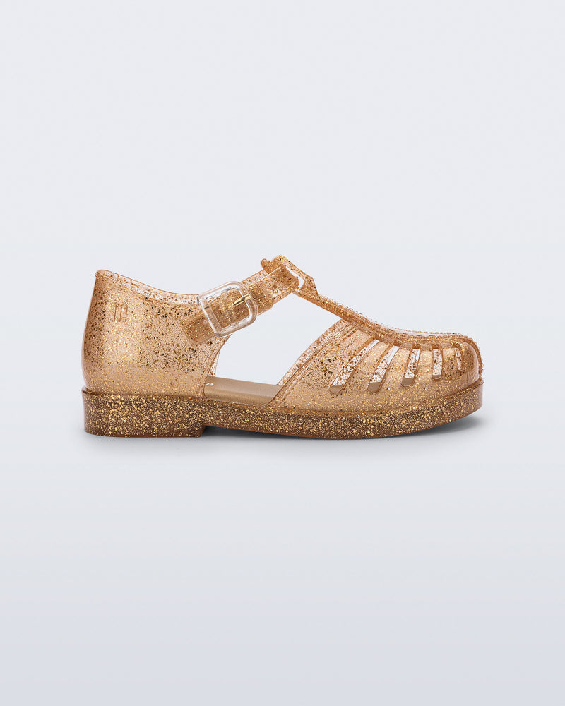 Side view of a glitter gold Aranha 79 baby flat with buckle