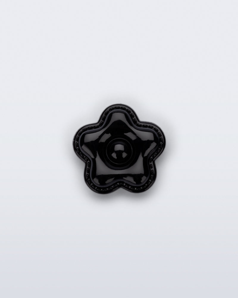 Front view of a black flower shoe charm