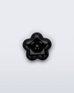 Front view of a black flower shoe charm