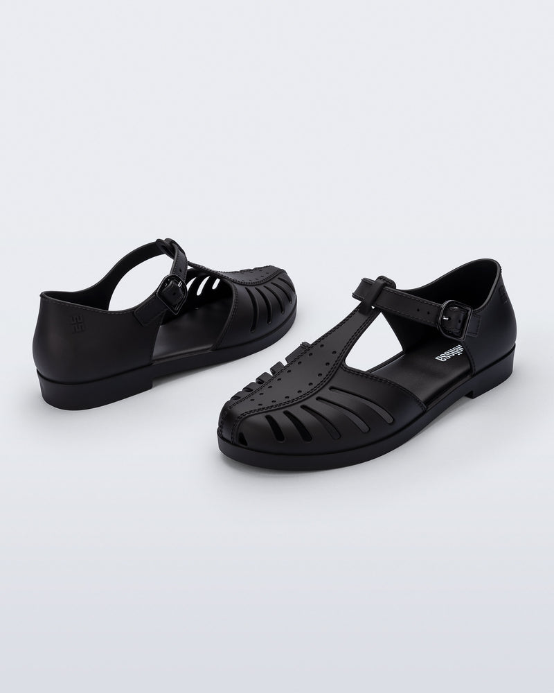 Back and angled view of a pair of black Aranha 79 flats with buckle