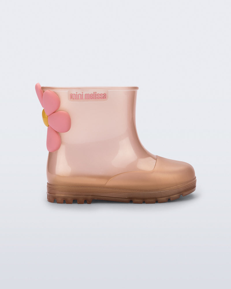 Side view of a pearly pink Welly Bloomy boot with pink daisy on back