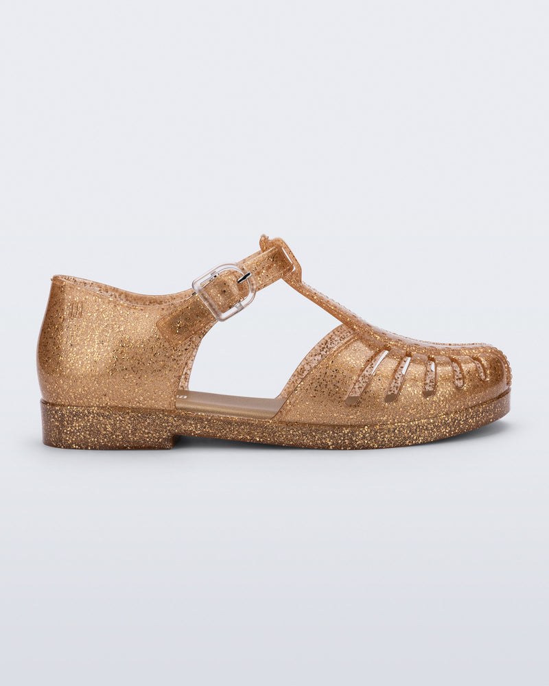 Side view of a glitter gold Aranha 79 kids flat with buckle