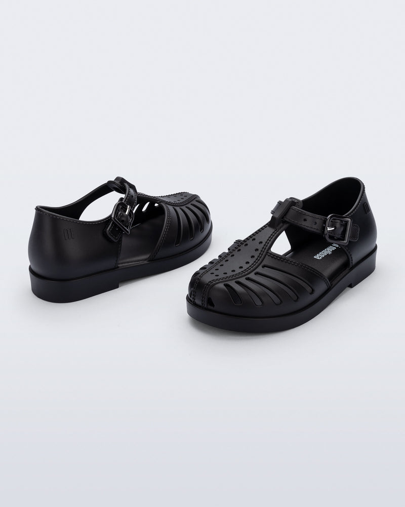 Side and angled view of a pair of black Aranha 79 baby flats with buckle