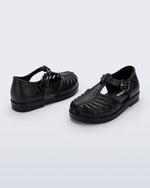 Side and angled view of a pair of black Aranha 79 baby flats with buckle