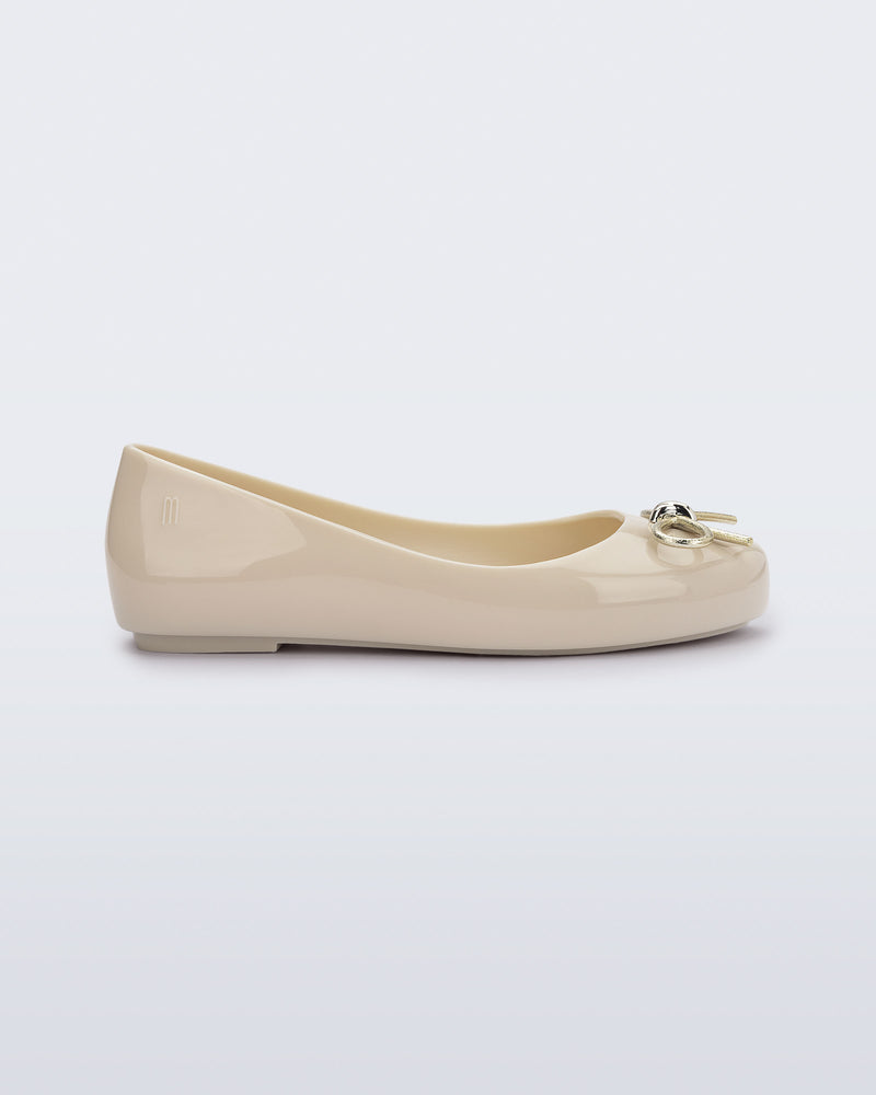 Side view of a beige Sweet Love Chrome kids flat with metallic gold bow