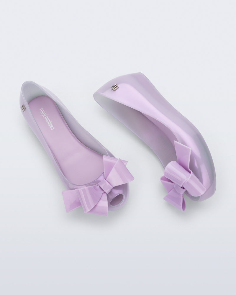 Side and top view of a pair of pearly lilac Ultragirl Classy kids flats with lilac bow