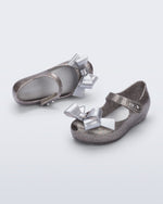 Top and angled view of a pair of silver glitter Ultragirl Classy baby flats with silver bow
