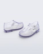 Side and angled view of a pair of clear Aranha 79 baby flats with buckle