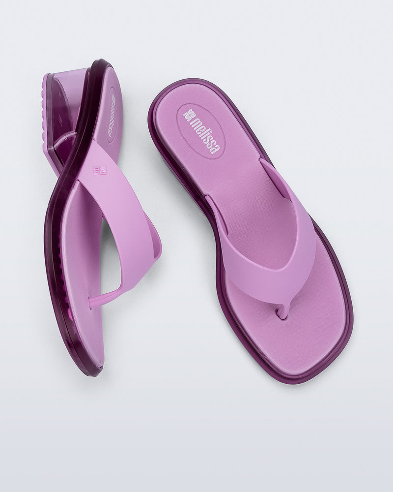 Top and side view of a pair of pink Margot flip flops with clear pink low heel