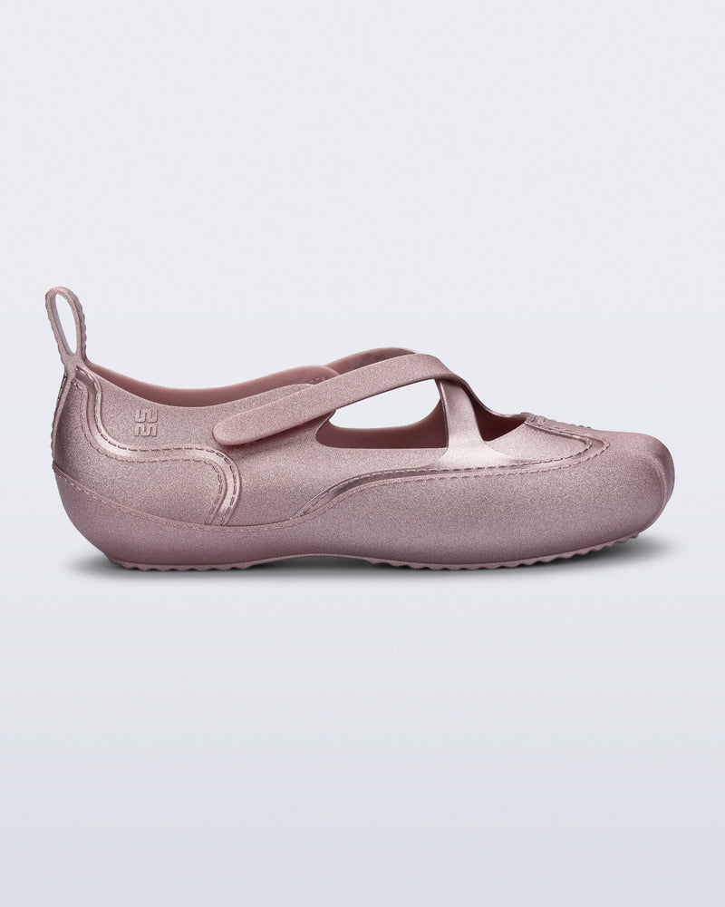 Side view of a pearly pink Aira flat with top straps