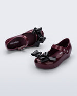 Top and angled view of a pair of burgundy Ultragirl Classy baby flats with black bow