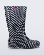 Side view of a black with white polka dots Welly rain boot