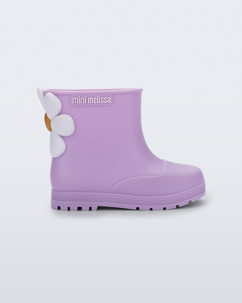 Side view of a lilac Welly Bloomy boot with white daisy on back