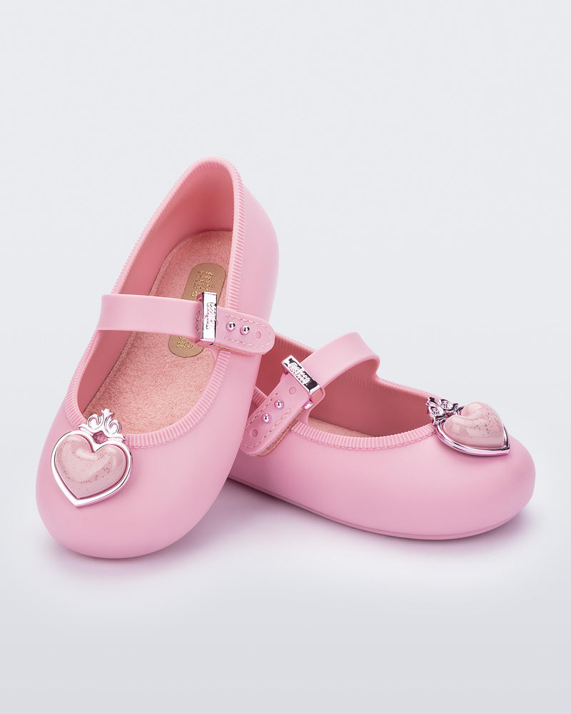 Angled view of a pair of pink Soft Ballerina Princess baby flats with a pink heart on top