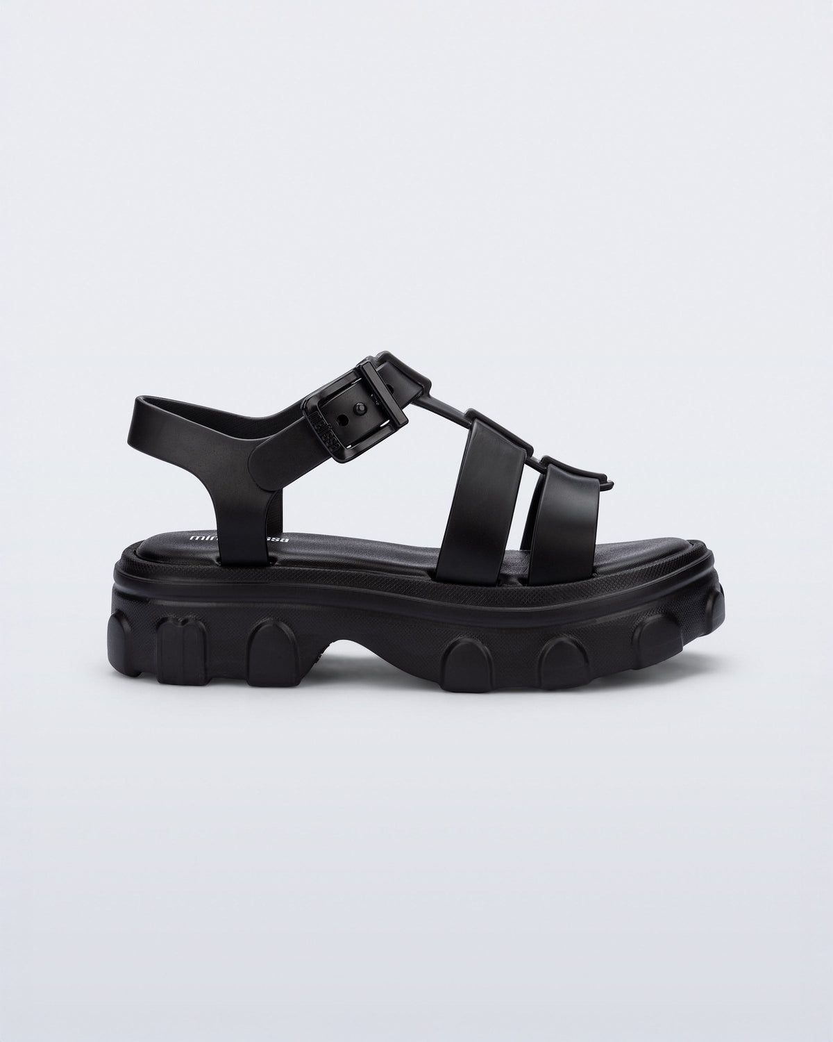 Side view of a black Ella kids sandal with heel strap