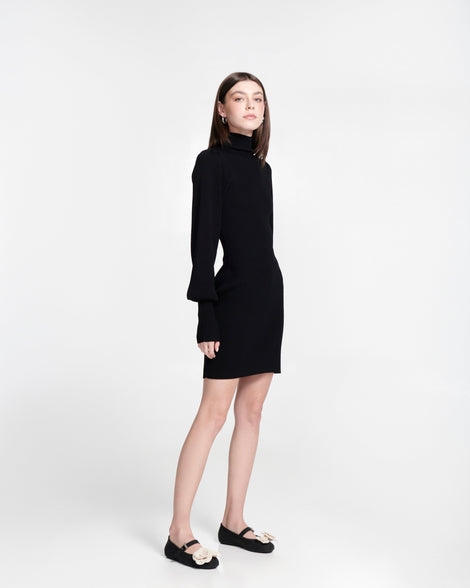 Model in a black dress wearing a pair of black Soft Ballerina Petals flats with beige flowers