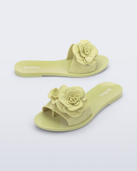 Side and angled view of a pair of green Babe Petals slide sandals