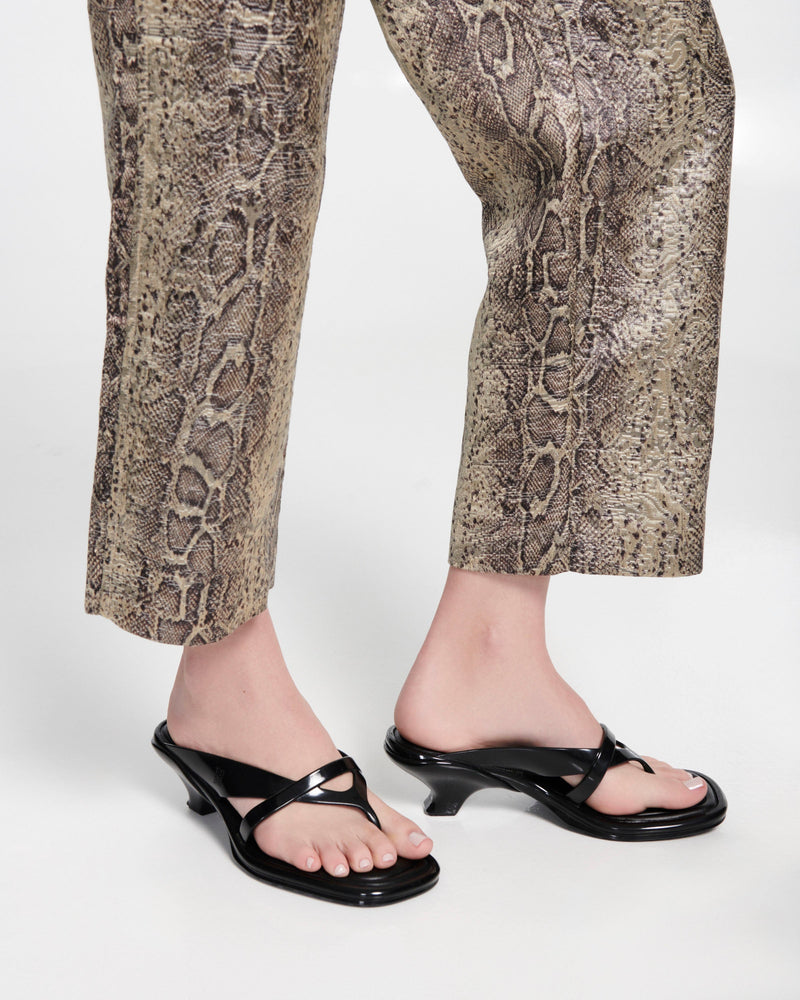 Model's leg wearing a pair of black Layla kitten heel flip flops