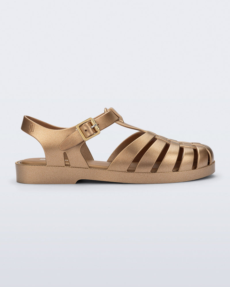 Side view of a gold Possession fisherman sandal