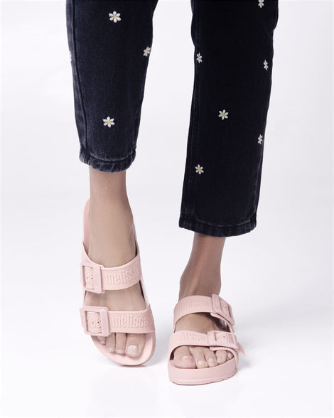 Model's legs wearing a pair of pink Cozy M Love adult slides