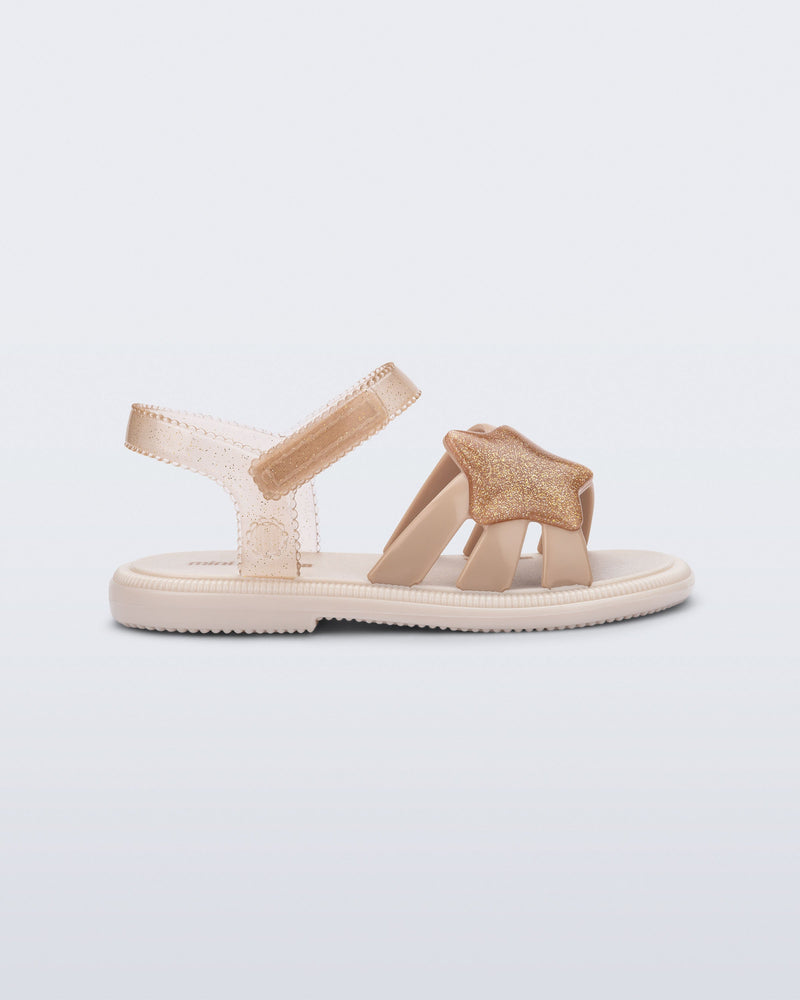 Side view of a beige Hip Sky baby sandal with a glitter beige star on top