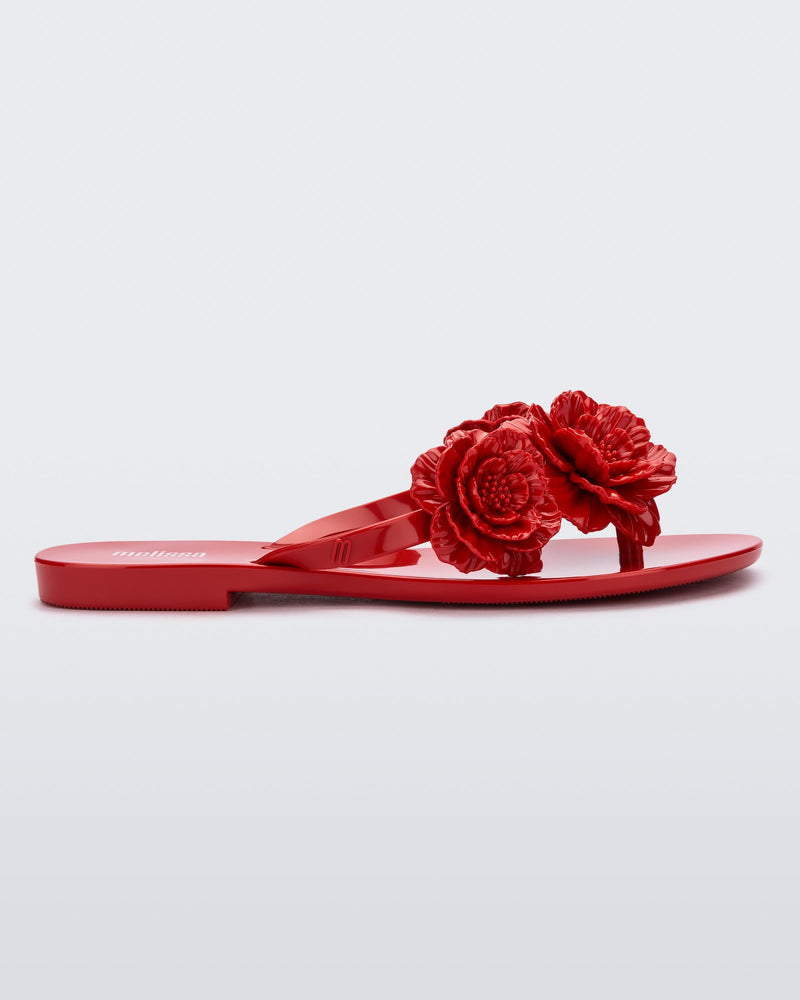 Side view of a red Harmonic Springtime women's flip flop with 3 red flowers.