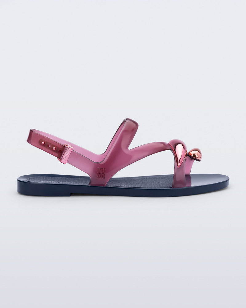 Side view of an pink Iris sandal with blue sole and rose gold upper embellishments