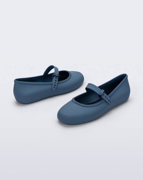 Side and front angled view of a pair of blue Soft Ballerina flats with top buckle strap