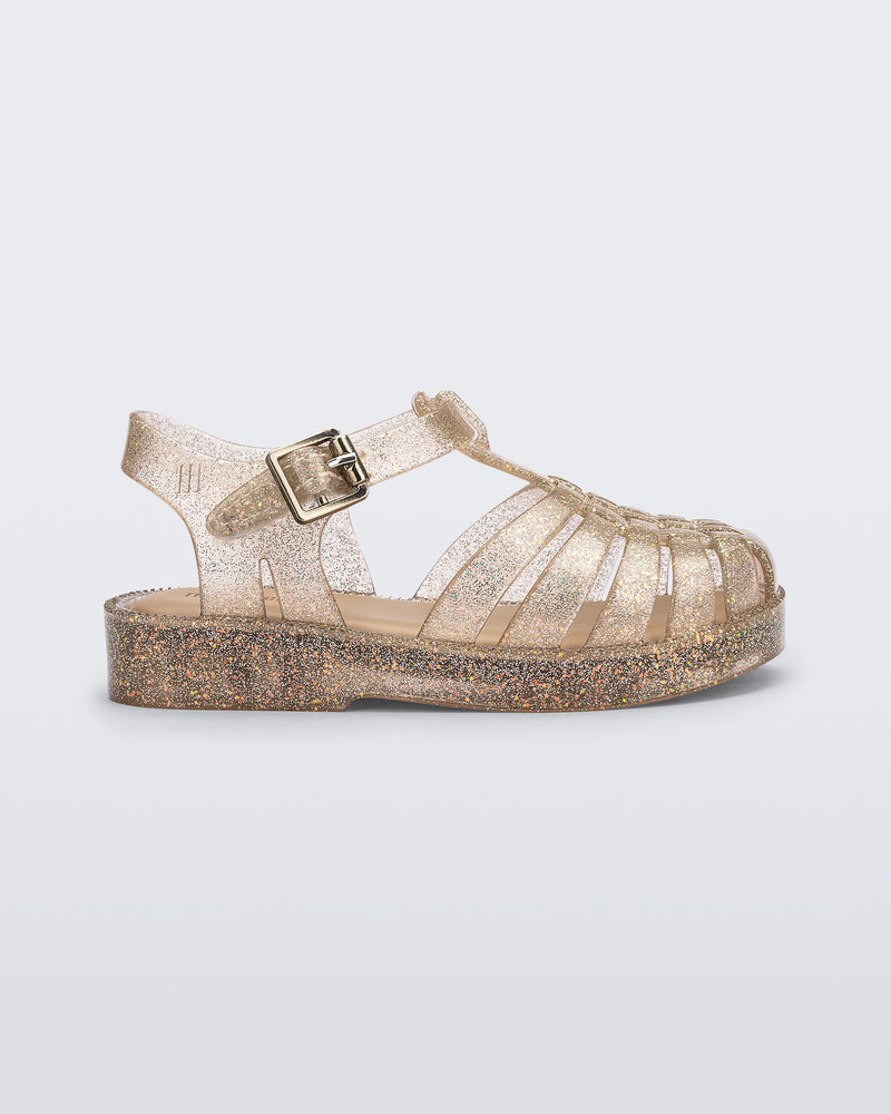 Side view of a glitter beige baby Possession sandal