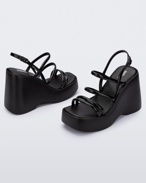 Angled view of a pair of black Jessie platform wedge sandals with side buckle ankle strap